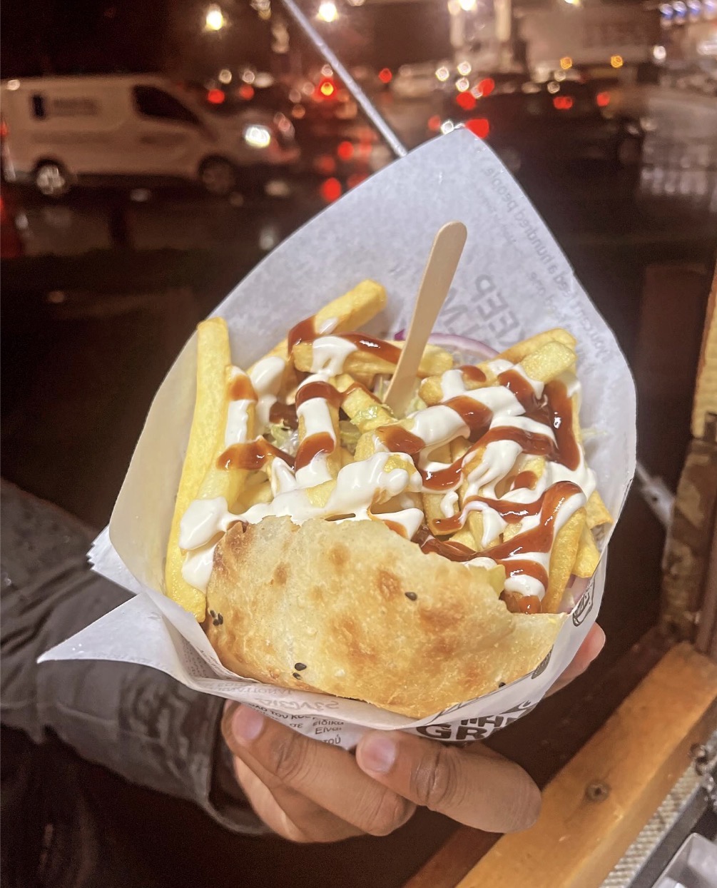 Puccia sandwich topped with chips and sauces held in a paper cone